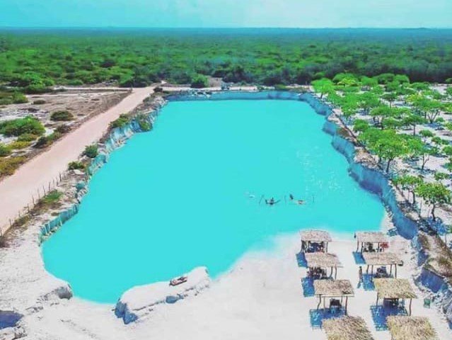 Imagem mostrando todo o espaço com a intensidade do azul das águas contrastando com entorno verde e arenoso.