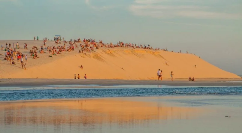 Imagem da Duna do Pôr do Sol repleta de pessoas prontas para acompanhar o espetáculo.