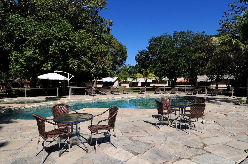 Imagem da piscina do hotel com mesas e cadeiras ao redor