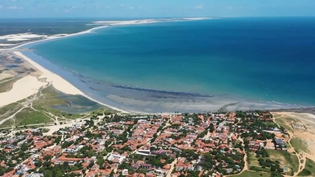 Vista aérea de Jericoacoara, com a vila em primeiro plano e o mar enorme à frente.